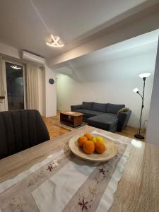 a plate of oranges on a table in a living room at Alex Apartment in Skopje