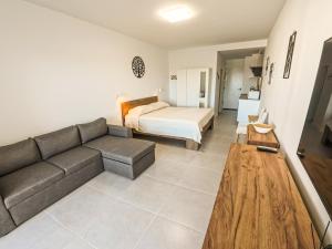 un soggiorno con un divano e un letto di Oasis de Jandia a Morro del Jable