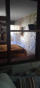 a bedroom with two beds and a stone wall at Casa Italiana 100m mar in Salvador +53 photos
