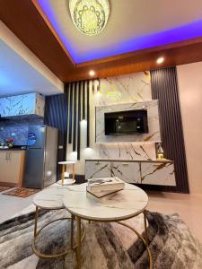 マニラにあるD' Caballero's Penthouse by Sun Residencesのリビングルーム(テーブル2台、テレビ付)