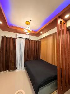 マニラにあるD' Caballero's Penthouse by Sun Residencesの青い天井のベッドルーム1室(ベッド1台付)