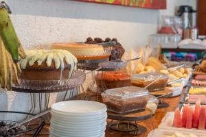 a buffet with cakes and other desserts on display at Pousada Sempre Graciosa in Praia do Frances