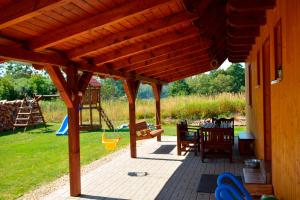a wooden patio with a table and a playground at Holiday Home Osada in Černý Dŭl