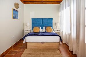a bedroom with a bed with a blue headboard at Luxury House Panoramic Sea Views in Güime +36 photos