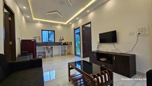 バガモンにあるSHI's Vagamon Hill Retreat- Private villa on Hillsのソファとテレビのあるリビングルーム