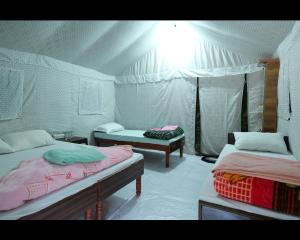 a room with two beds in a tent at Hill dew camps in Uttarkāshi
