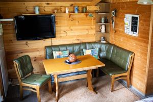 a living room with a table and a couch and a tv at Ferienhäuschen in Beetz - in 5 min am See und Wald in Kremmen