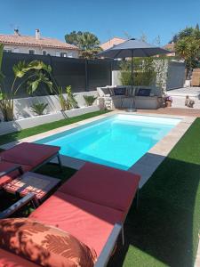 basen z 2 leżakami i parasolem w obiekcie Jolie villa Lalou Côte d'Azur trois chambres w Fréjus