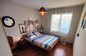 a bedroom with a bed and a window in it at La Suite Soleil in Gujan-Mestras