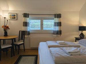 ein Schlafzimmer mit zwei Betten und einem Tisch und einem Fenster in der Unterkunft Stop & Sleep Ybbs in Ybbs an der Donau