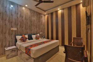 ein Schlafzimmer mit einem großen Bett und einem Stuhl in der Unterkunft Hotel Ramayan Premium Best Family Hotels with Free Pickup From Ayodhya Dham Railway Station in Ayodhya