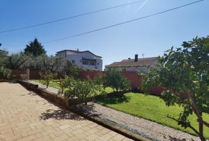 a garden with trees and a building in the background at Casa Sol Maris in Novigrad Istria