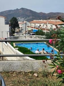 una vista de una piscina con gente en ella en Maison dans Résidence piscine, en Roses