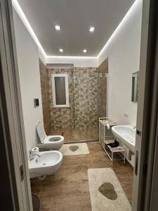 Un baño con dos lavabos, un inodoro y una ducha. en Tramonti a sud, en Agrigento