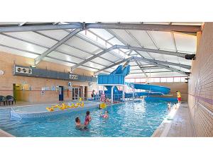 a large swimming pool with people in the water at Jasmine Corner - entertainment passes included - message for longer stays in Ringwood