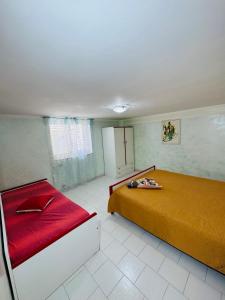 ein Schlafzimmer mit einem Bett und einer rot-gelben Decke in der Unterkunft Porta Marina Ascea Marina Velia in Marina di Ascea