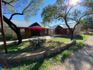 una casa con una mesa y una sombrilla roja en Cabin 6 The Roost Cabins, en Lakehills