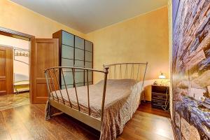 een slaapkamer met een bed in een kamer bij Shyval Apartment Vosstaniya 35 in Sint-Petersburg