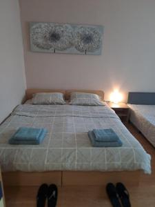 Un dormitorio con una cama con dos toallas azules encima. en LevskiG Studio 10 min from Sofia Airport and city centre, en Sofía