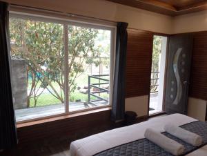 a bedroom with a bed and a large window at Misty Valley Inn in Kodaikānāl