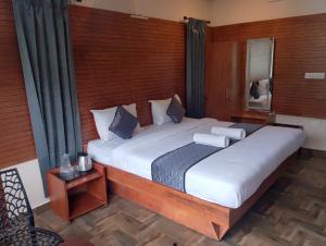 a bedroom with a large bed and a window at Misty Valley Inn in Kodaikānāl +44 photos