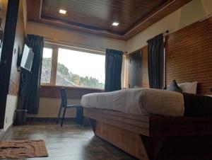 a bedroom with a large bed and a window at Misty Valley Inn in Kodaikānāl