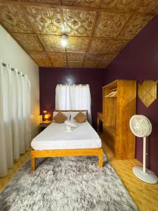 a bedroom with a bed with a table and a rug at Cecilia's Garden Guesthouse in Siquijor