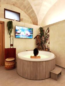 a woman sitting in a round tub in a bathroom at Chez Liart 2 in Fasano