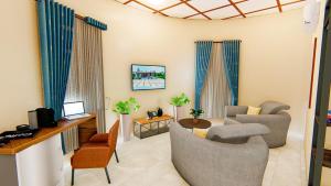 a living room with a couch and chairs and a desk at Serengeti legacy Lodge in Lukungu