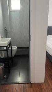 a bathroom with a toilet and a sink and a bed at Pristina Kosovo Inn in Pristina