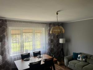 a living room with a table and a couch at Domek Nad Stawem in Objazda