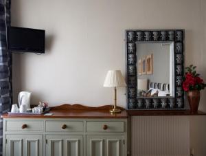 a mirror on top of a dresser with a lamp at The Gallery in Blackpool