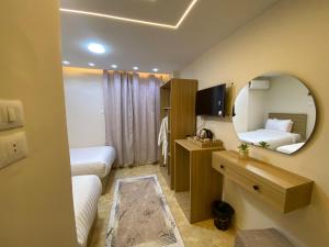 a hotel room with two beds and a mirror at Isis Pyramids View Inn in Cairo