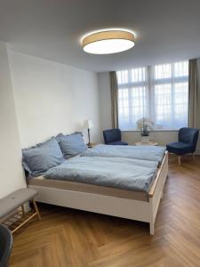 una camera con un grande letto e due sedie blu di Emelie a Thun