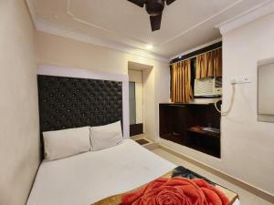 a bedroom with a bed with a black headboard at Hotel Al Sana in Kolkata