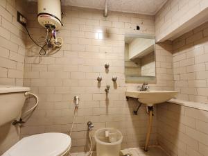 a bathroom with a toilet and a sink at Hotel Al Sana in Kolkata +71 photos