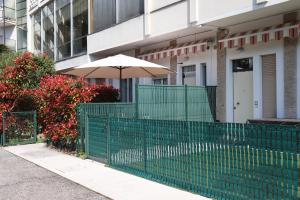 una recinzione verde con un ombrello di fronte a un edificio di Monika Holiday 5 Lake Garden a Garda Altre 142 foto