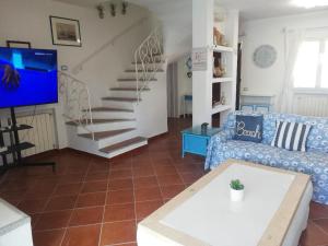 a living room with a couch and a staircase at Domus Eleonora a due passi dal mare in Golfo Aranci