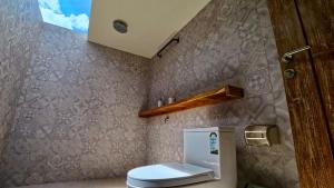 a bathroom with a toilet in a room at SA Oeona Bungalow in Nembrala