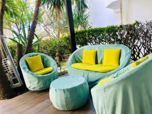 two blue chairs with yellow pillows on a patio at Ksar Rimal par Immo Marina Vacances de Rêve MF in Marina Smir +1 photo