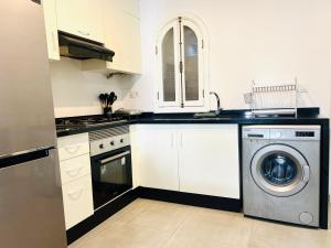 a white kitchen with a washing machine in it at Ksar Rimal par Immo Marina Vacances de Rêve MF in Marina Smir