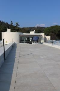 un edificio con patio con tavolo e ombrellone di Monika Holiday 5 Lake Garden a Garda