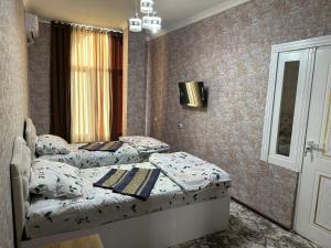 two twin beds in a bedroom with a window at Toxir Guest House in Samarkand