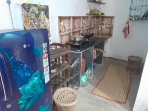 a kitchen with a stove and a refrigerator at Ganga river House in mayapur