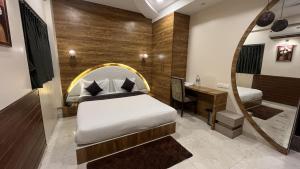 a bedroom with a bed and a mirror and a desk at Hotel Ranjeet in Ahmadnagar