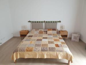 a bedroom with a bed with two nightstands and two tables at Casa Vacanza Mattirolo - Castagneto Po in Castagneto Po