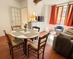 a kitchen and living room with a table and chairs at La petite maison in Noyers +12 photos