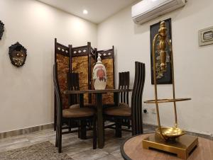 une salle à manger avec une table, des chaises et une horloge dans l'établissement Korean Style 2BHK with City Views & Free Netflix, à Rawalpindi