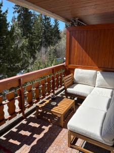 a porch with a couch and a coffee table at Appartement Crans-Montana in Crans-Montana