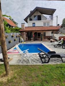 a house with a swimming pool and two lounge chairs at Kuća za odmor Pinka House in Sveti Ivan Zelina